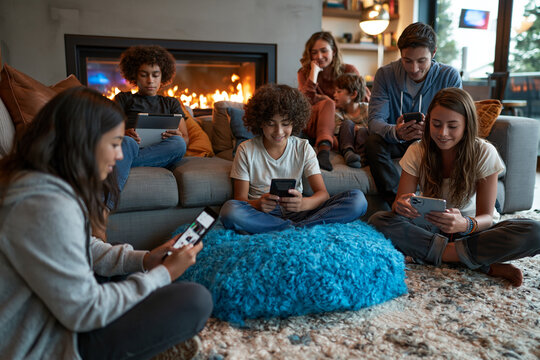 Family Using Smartphones and Digital Tablets in Living Room