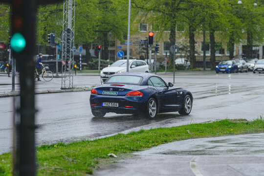 Gothenburg, Sweden - May 10 2026: Dark BMW Z4 coupe waiting at rainy city intersection.