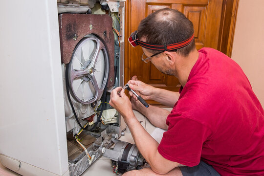 The man is repairing the washing machine.