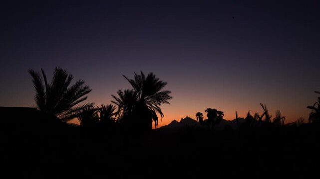 Scenic view of golden sun rising from behind coastal mountain peak along the Red Sea beach in Neom