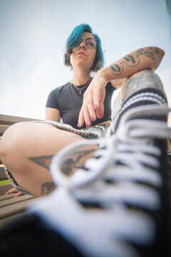 Confident gen z alternative woman with blue hair and headphones with copy space