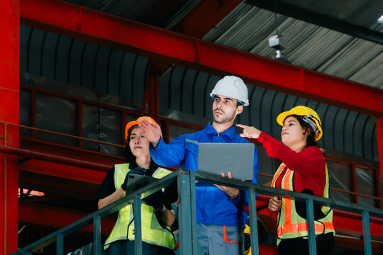 Industrial engineer team working with laptop, feeling focused and confident, discussing construction project in modern factory building