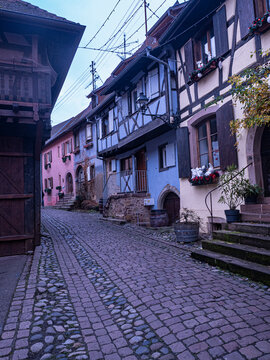 Calle adoquinada con casas tradicionales de entramado de madera en Alsacia, Francia
