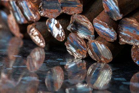 Stack of rusted steel rods with unevenly cut ends, raw metal structure, corrosion, industrial texture, and character of steelmaking and metallurgical products
