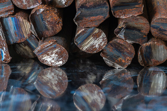 Stack of rusted steel rods with unevenly cut ends, raw metal structure, corrosion, industrial texture, and character of steelmaking and metallurgical products