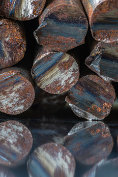 Stack of rusted steel rods with unevenly cut ends, raw metal structure, corrosion, industrial texture, and character of steelmaking and metallurgical products
