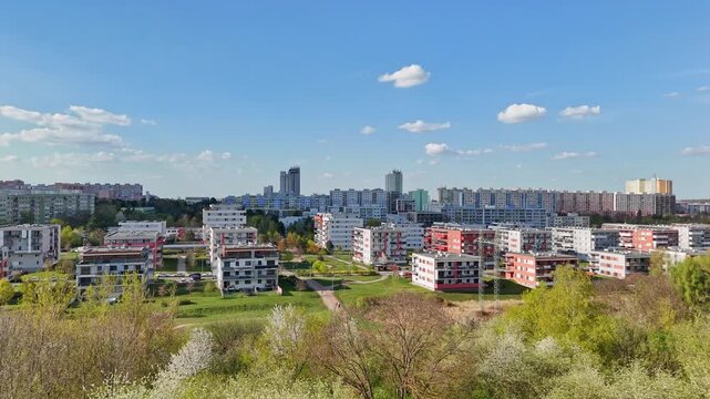 Panoramic drone view of Prague 4 residential district in spring. aerial shot captures the diverse architecture of the Prague blooming spring trees, and walking paths weave through the urban landscape