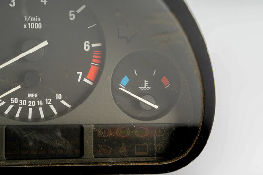 Dashboard gauge showing vehicle speed, fuel level, and engine temperature in a car