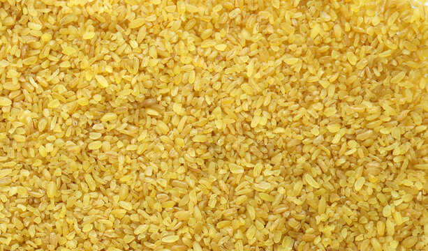 Detailed view on bulgur cereal grains in big pile on table close up