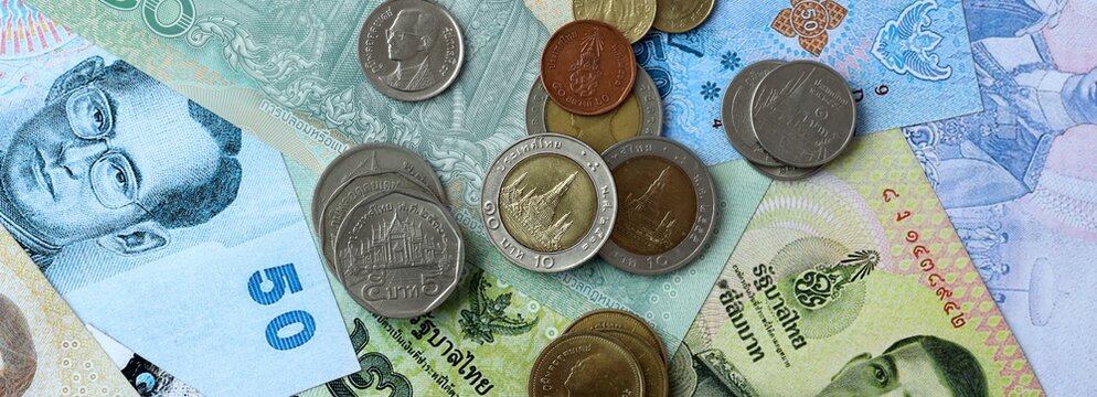 Thai baht money banknotes and coins on table. Thailand cash bills of THB currency