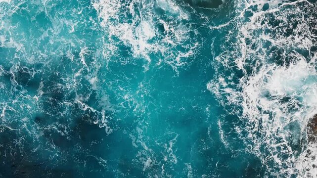 Turbulent Atlantic Ocean surface with waves and scattered sea foam. Overhead aerial footage of churning seawater