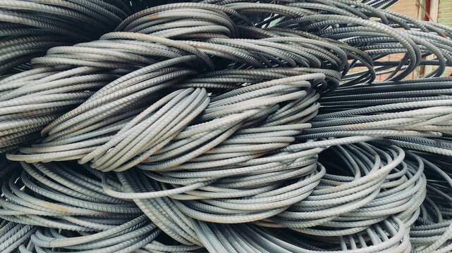 Stack of coiled silver steel reinforcement rods for construction