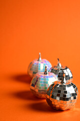 Naklejka premium decorative disco ball pumpkins arranged on orange background with reflective tiles for autumn and party theme