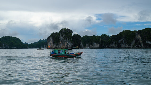 Traditional Boat Sailing Among Limestone Karsts in Ha Long Bay, Vietnam
