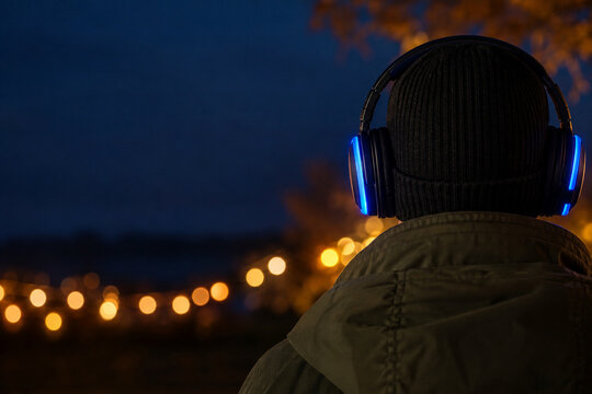 Rear view of a guest wearing glowing headphones at an outdoor event