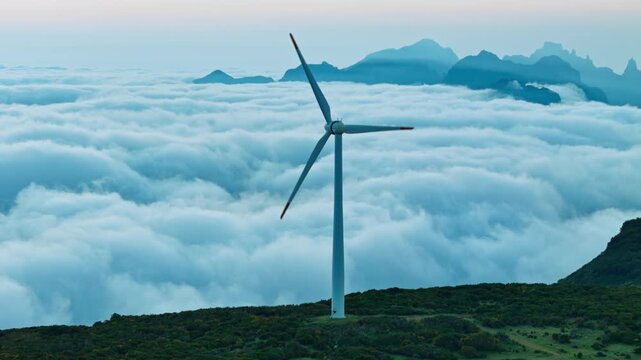 Wind farm in mountainous region above clouds in Madeira, renewable energy expansion and energy transition
