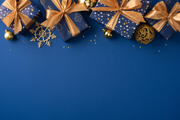 Naklejka premium Festive blue wrapped presents with gold bows and ornaments for Christmas and New Year celebration on deep blue space