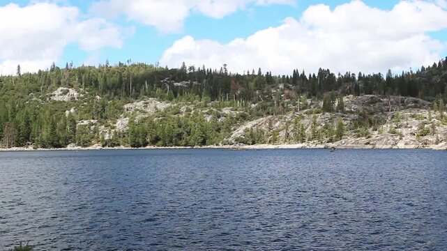 Small Waves On Lake With Tree Covered Mountain Blue Sky White Clouds And Boats In Background Pinecrest California
