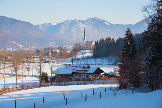 winter scenery Bad Wiessee. snowy landscape and farm house. church Maria Himmelfahrt