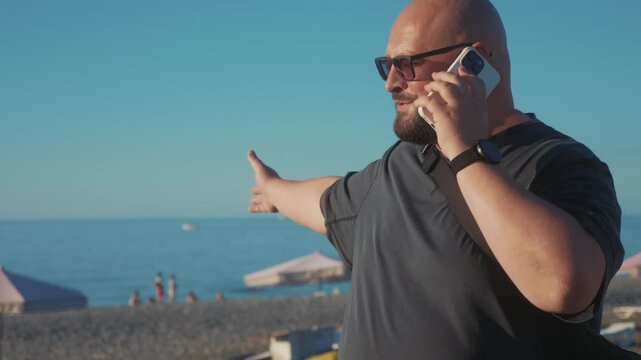 Phone conversation, traveler talks on smartphone beside seaside beach during summer vacation, casual mobile communication, tourism lifestyle, outdoor connectivity.