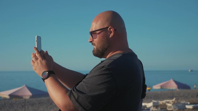 Tourist filming sea and beach resort landscape on smartphone during summer vacation, mobile travel content creation by seaside.