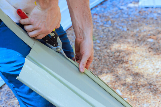 Person using tools to cut facade siding in construction area
