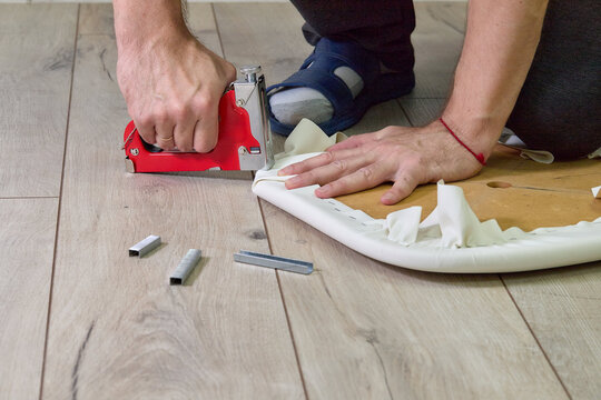 Indoor installation work: staple gun, fabric, wooden base, wooden floor 