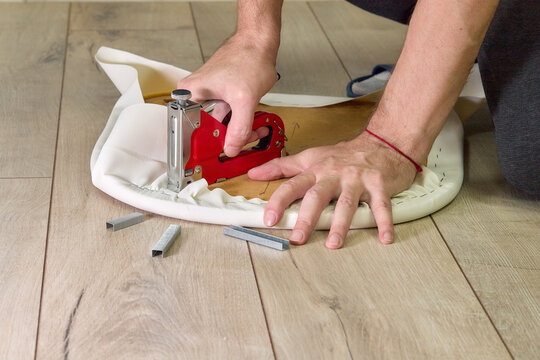 Indoor installation work: staple gun, fabric, wooden base, wooden floor 