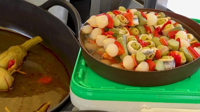 Close up view of traditional spanish banderillas skewers, marinated artichokes and crispy torreznos pork rinds at a local market stall.