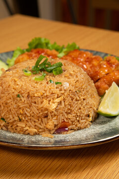 Des plats de riz frit tha&iuml;landais sur une assiette avec l&eacute;gumes et citron
