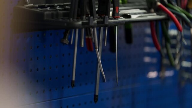 Screwdrivers hanging on tool rack in automotive repair workshop