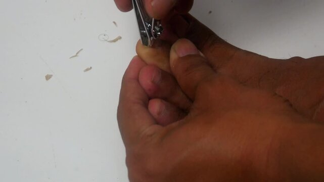 someone is cutting the nails on their toes using a nail clipper