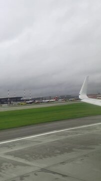 Rainy airport view: aircraft wing and terminal on a cloudy day