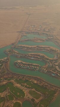 Aerial view of desert oasis residential development with blue lagoons