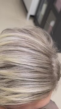 Shiny textured ash blonde hair with subtle highlights in natural light