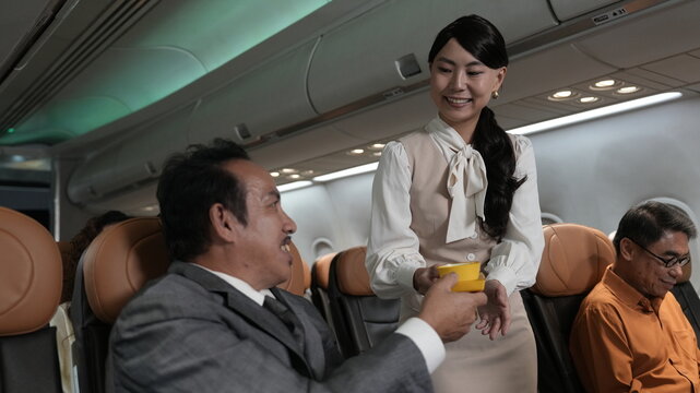 Flight attendants are serving passengers and providing in-flight safety instructions.