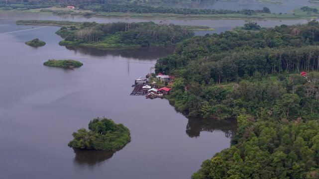 Aerial view captures a calm river flowing through lush green islands at Tasik Raban
