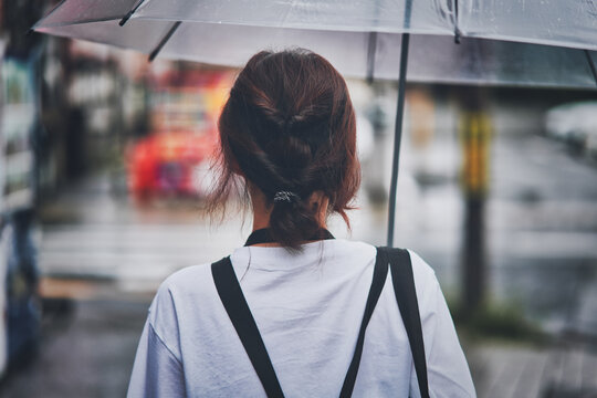 雨傘を差す女性の後ろ姿