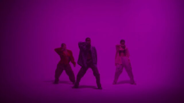 Dancer class Professional choreographer dancing with backup dance on color changing neon in studio for dance video clip. Four women dancers showing hip hop movements. Advertising of dance school.