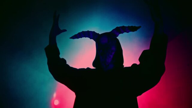 Demon with horns crawling in corridor. Silhouette of devil in darkness. Halloween, a traditional American holiday concept. Evil magician making rite or sacrifice during full moon, evil spirit, satan.