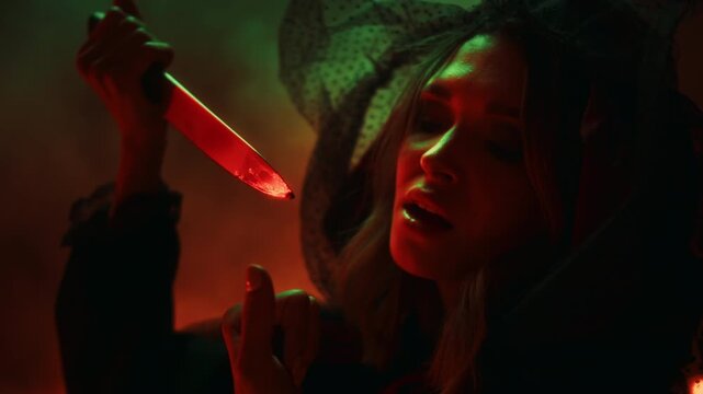 Halloween Witch casting a spell with candles during an exorcism ritual, scary sorceress in Halloween costume performing dark magic, spooky horror movie atmosphere.