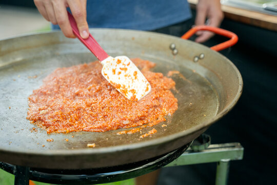 Cooking traditional spanish paella base in large pan