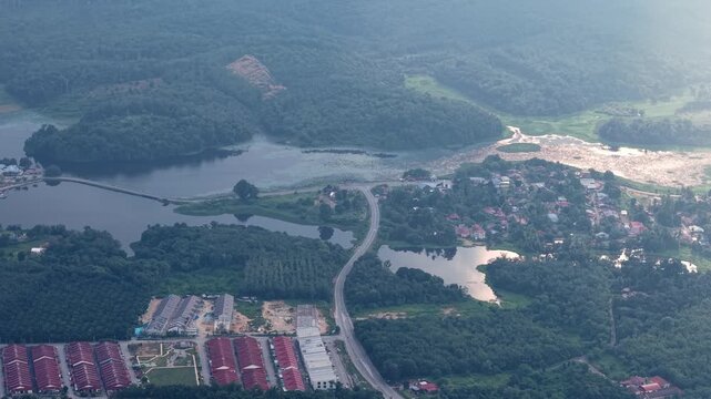 Aerial view reveals interconnected lakes and dense forests. Bridge spans the water at Tasik Raban