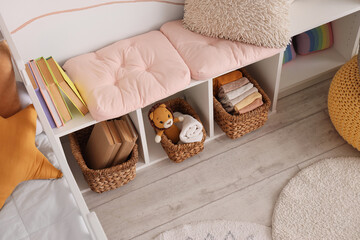 Home organization and nursery storage, tidy children room with wicker baskets and books on white shelving unit for interior design and lifestyle © Pixel-Shot