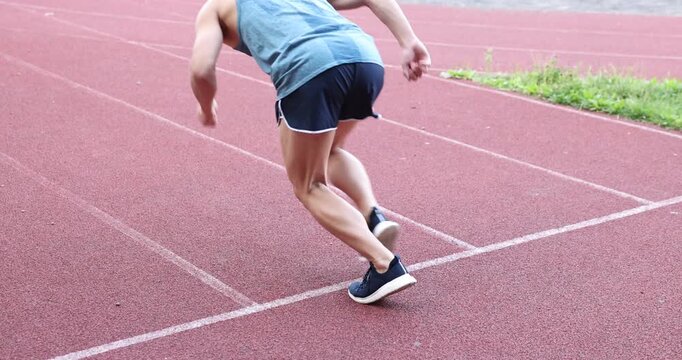 Athlete man getting into start position and running at stadium