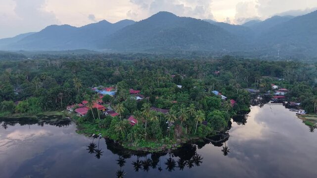 Aerial view captures a tranquil lake reflecting lush mountains at Tasik Raban