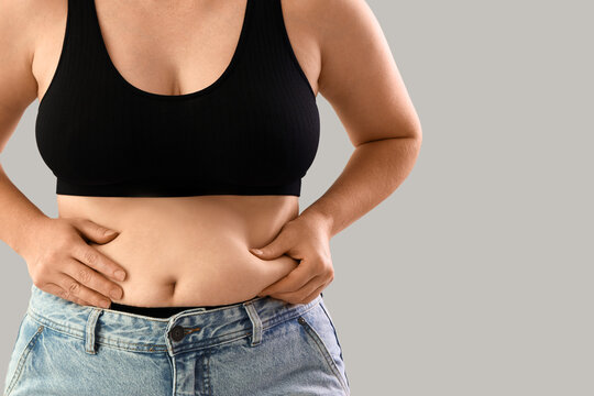 Overweight woman on grey background