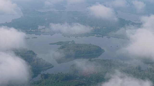 High angle view of misty lakes and green islands from above at Tasik Raban