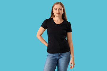 Fototapeta premium Young woman in stylish black t-shirt on blue background