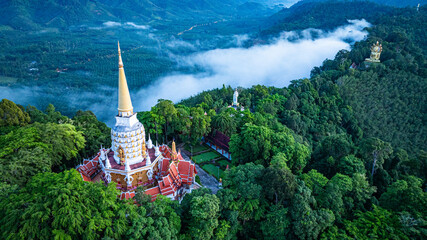 Peaceful sunrise landscape featuring Wat Bang Riang, tropical mountains, forest, clouds, and...